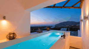 Private outdoor hot tub on a suite terrace with an open Santorini view at dusk, no people in frame